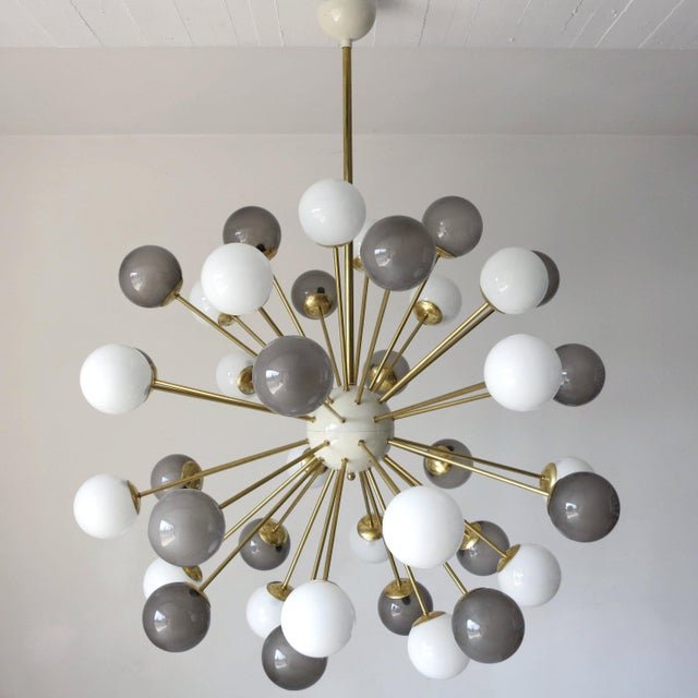 Italian sputnik chandelier with 40 Murano glass globes in glossy gray and glossy white color, mounted on brass frame in...