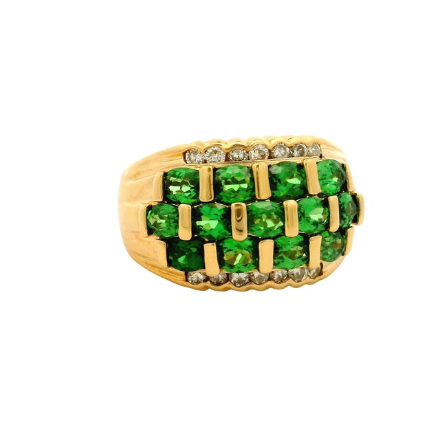 A striking band ring featuring 2.50 carats of oval tsavorite garnets. The vibrant green stones are set in a structured...