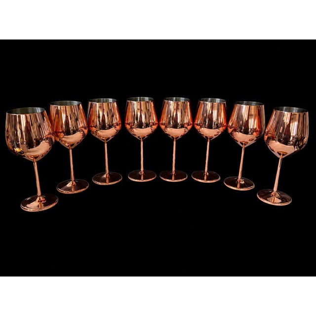 A striking set of seven vintage copper stemmed goblets featuring a polished rose gold metallic finish and sculptural...