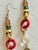 Vintage 1990s gothic tribal shoulder duster earrings featuring an eclectic vertical arrangement of cast metal, glossy red...