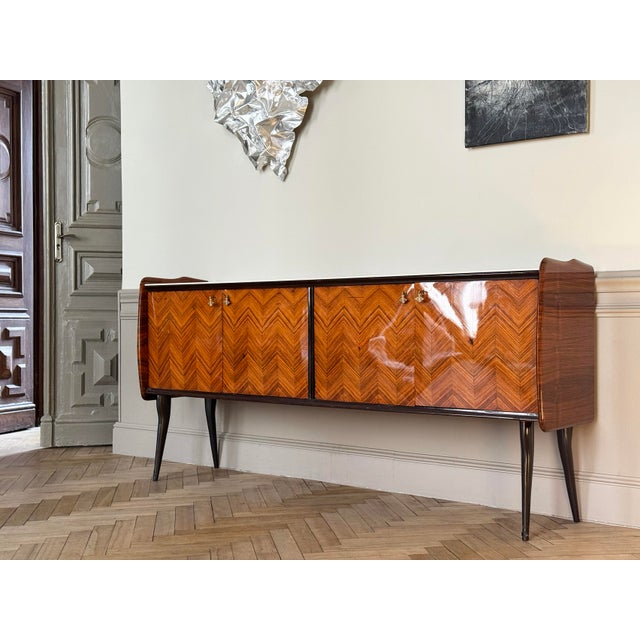 Italian vintage sideboard. Exclusive chevron wood veneer. Sleek, gently rounded side shapes recall the golden age of 20th-...