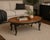 Vintage Oval Coffee Table – Bookmatched Veneer Top in Satin Walnut with Black & Gold Gilded Base – 48" W A refined...