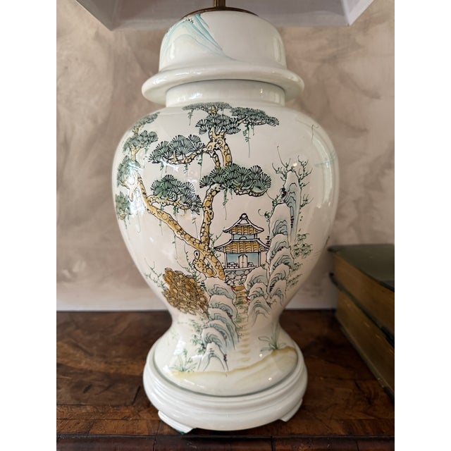 This is a vintage Chinese export ceramic table lamp featuring a hand-painted Chinoiserie landscape scene with pagoda...