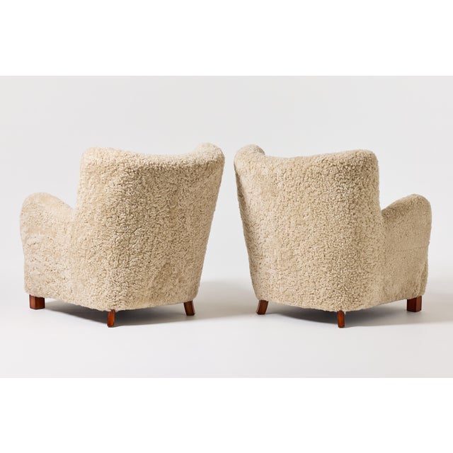 An elegant pair of Danish Modern armchairs from 1940s Denmark, distinguished by their sculptural silhouette and inviting...