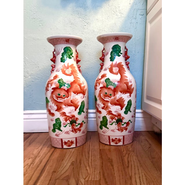 Vintage Chinese Porcelain Vase With Foo Dog Motif, a Pair. Marked on bottom. Circa 20th century. Painted in iron red,...