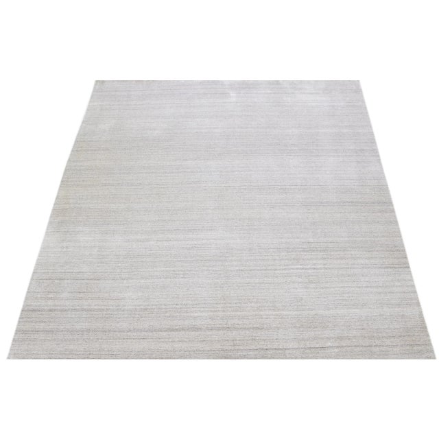 A stunning modern Gabbeh-style hand-woven wool rug boasting a light gray color field and exquisite solid design. This rug...