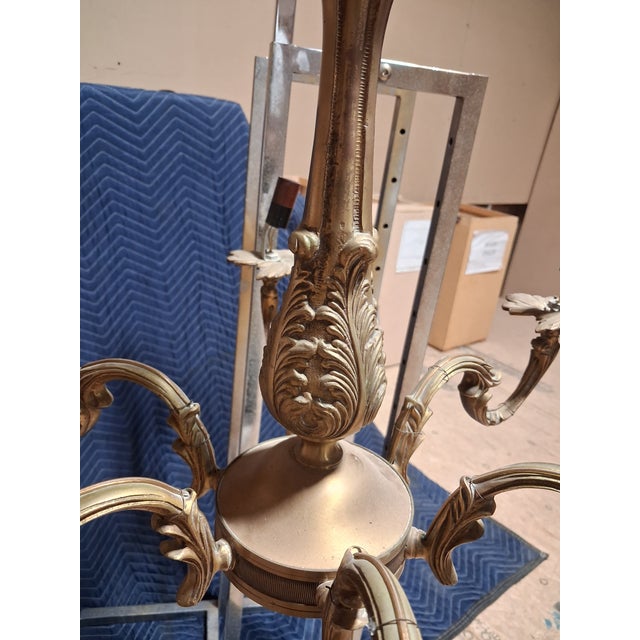 An elegant French Louis XV style six-light chandelier featuring gracefully scrolling Rococo arms, richly cast acanthus...