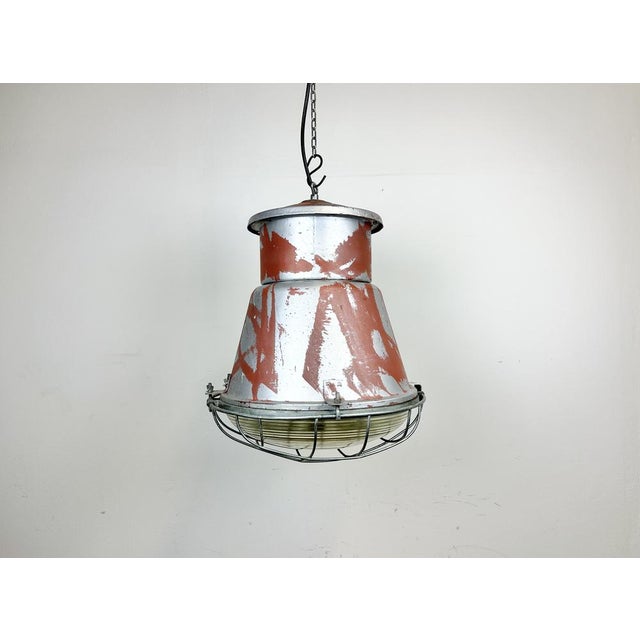 Vintage industrial hanging lamp manufactured in 1970s by mesko in skarzysko-kamienna in poland. It features a grey iron...