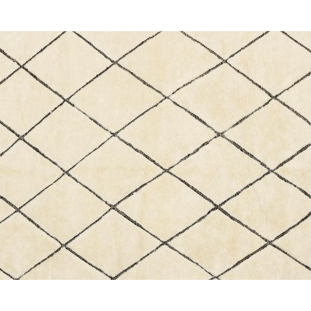 Classic hand-knotted wool rug featuring a textured flat-woven diamond pattern in Midnight Black on a soft Ivory backdrop,...