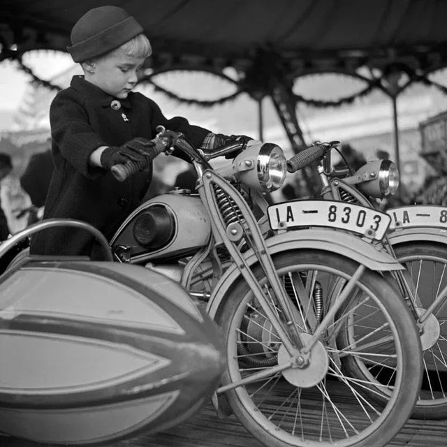 The photographer's note regarding this work is "A little boy on the motorbike of a kiddy carousel at the christmas market,...