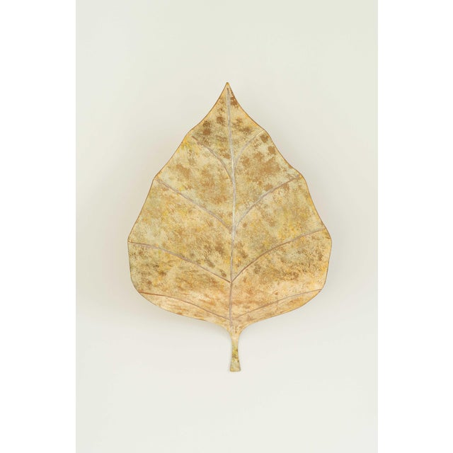 A pair of large hand-painted gold French tôle leaf wall sconces, circa 1970s, Hollywood Regency in spirit with an organic...