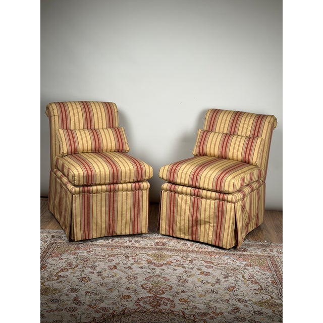 This inviting pair of upholstered slipper chairs combines a classic low, armless profile with generous cushioning and a...