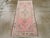 A vintage Turkish Oushak throw rug. The rose-grey semi-open field displays a sand medallion with small stylized flower...