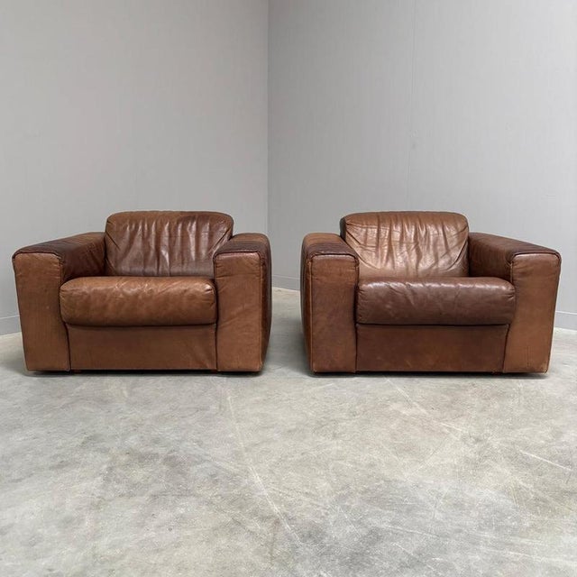 Set mid century lounge chairs, 1970s. In the manner of De Sede DS105. Wooden frames with brown leather upholstery. Chairs...