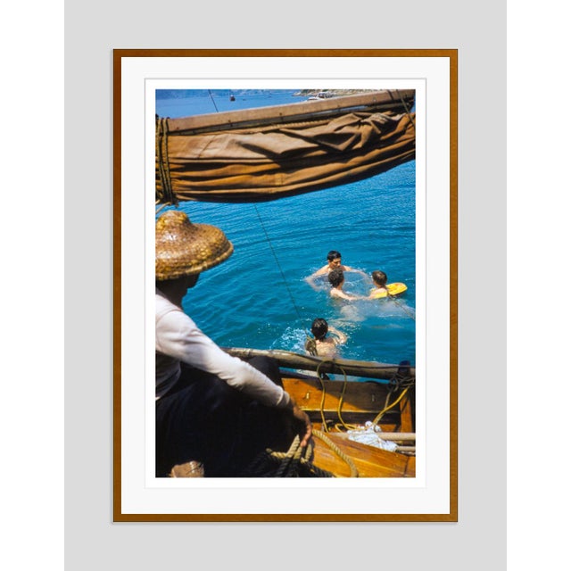 Hong Kong Swim by Toni Frissell A family take a swim from a junk boat in Hong Kong, with the boat man looking on, 1960....