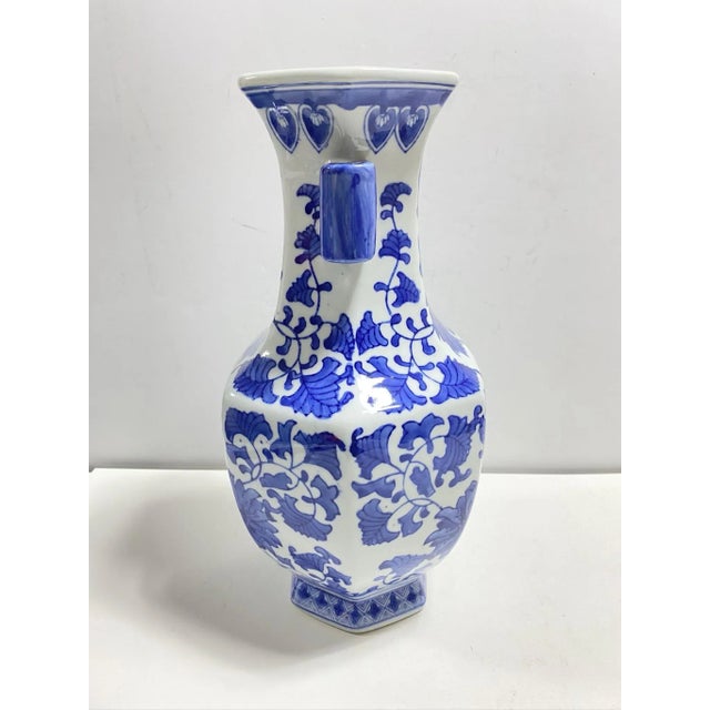 A striking 14-inch vintage blue and white porcelain vase featuring lush floral motifs in saturated cobalt glaze. The...