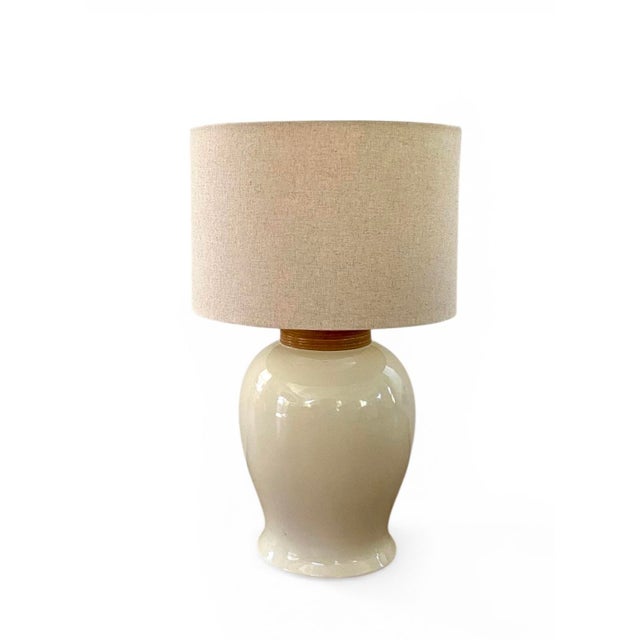 Pair of high-gloss, ivory ginger jar formed table lamps with woven rattan trim. Hollywood Regency style, date late 70's,...
