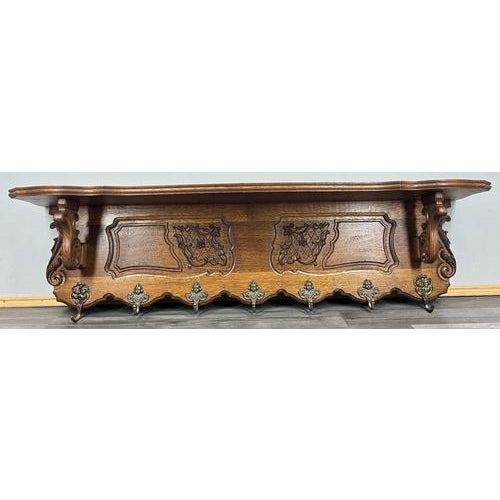 This elegant Vintage French wall-mounted coat rack is crafted in oak and features richly carved decorative panels, a...