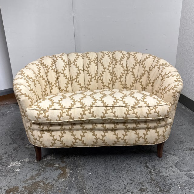 Design Plus Gallery presents a Danish Banana Style Channel Tufted Loveseat. This upholstered loveseat showcases a curved,...