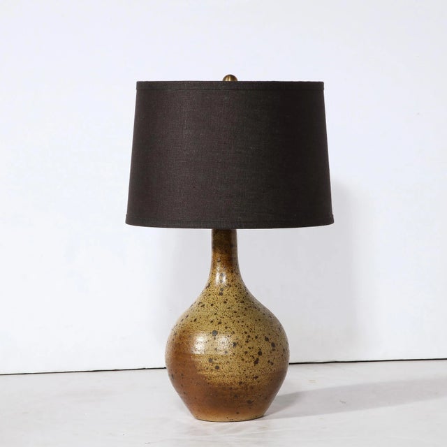 This sophisticated Mid Century Modern table lamp was realized in France circa 1960. It features a tear drop form with a...