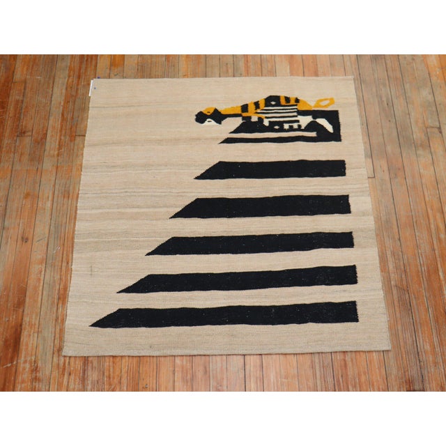 Square scatter size Persian Kilim from the 20th century with a stand alone penquin on a khaki ground. This was originally...