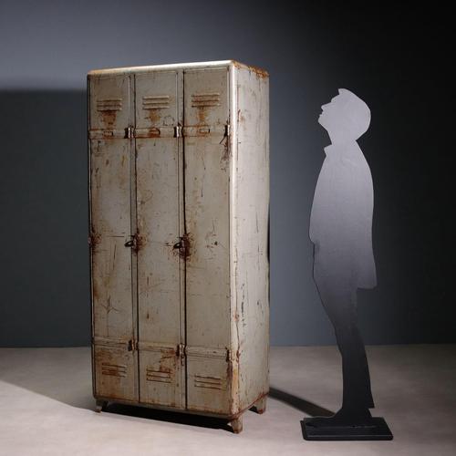 Industrial metal cabinet with three doors and coat rack. This piece is attributed to the mentioned designer/maker. It has...