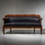 Large Biedermeier sofa raised on four slightly curved square legs, featuring a rounded backrest that terminates in...