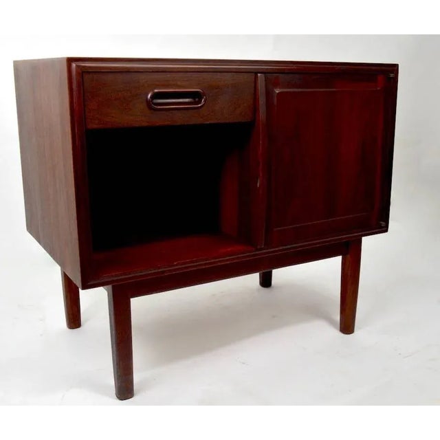 Very good quality Danish modern night table, featuring one drawer, over an open storage cubby, flanked by a door which...