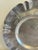 This round hammered aluminum tray features a hand-chased rose motif worked into a wide, ruffled scalloped rim, in the...