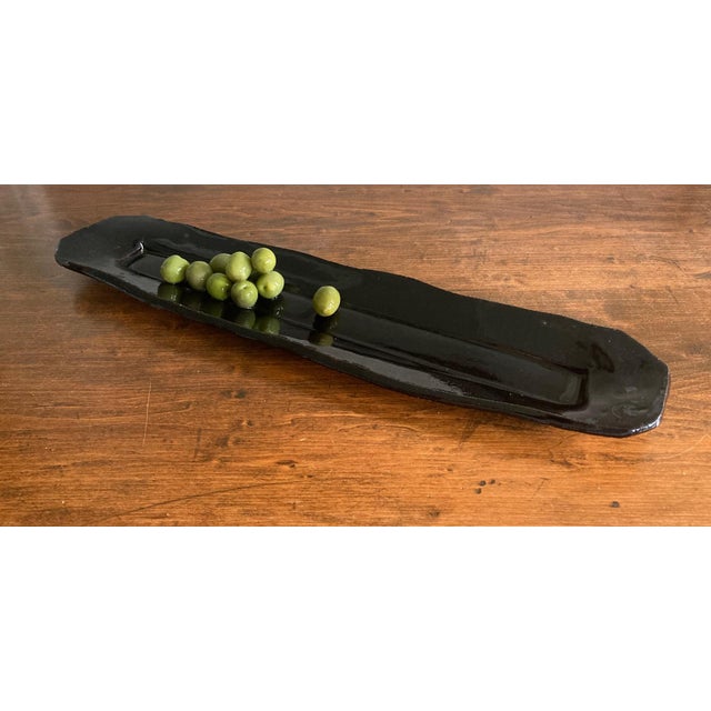 This ceramic platter used a commonplace 2x4 piece of lumber for its initial form. Glazed in an intense dark blue, it...