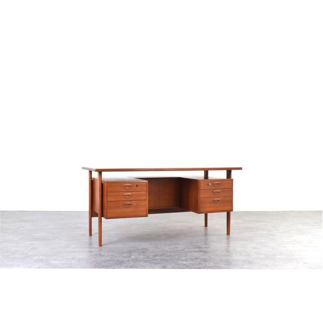 This teak desk, model 60, was designed in the 1960s by Danish designer Kai Kristiansen and manufactured by Feldballes...
