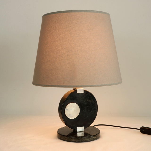 A stunning and elegant table lamp made in the 1970s, characterized by a strong Art Deco Revival style. The central body is...