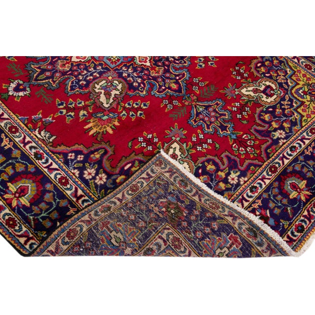 Beautiful vintage Persian Tabriz hand-knotted wool rug with a navy blue color field. This piece has a navy blue frame and...