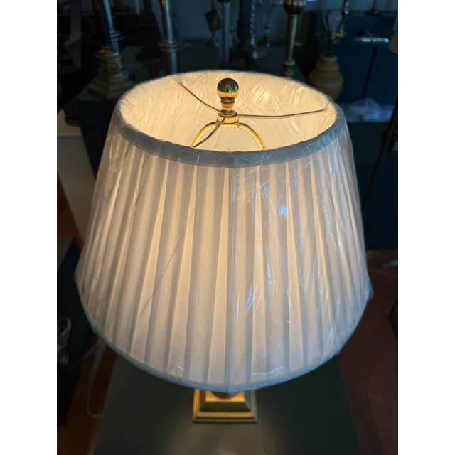 A Haig table lamp featuring a fluted crystal column supported by a stepped base with brass accents. The elegant column...