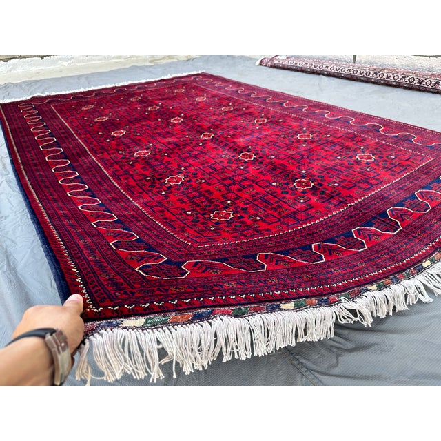 This vibrant Aqcha rug showcases a grid of small star-shaped medallions in ivory and navy, spread evenly across a bold...