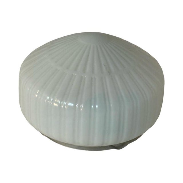 Art deco style lamp made from a metal base that houses an opaline dome. The dome is secured in place with a spring...