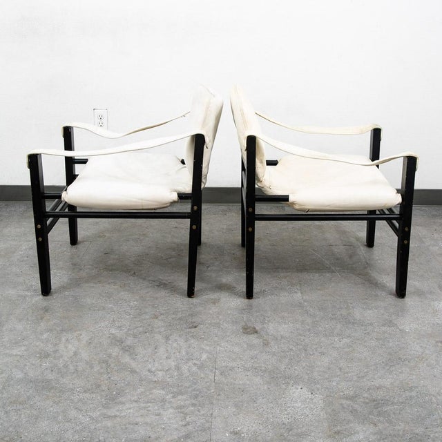 Set of white leather safari chairs with black frames. Unsigned examples. This set was recently imported directly from...
