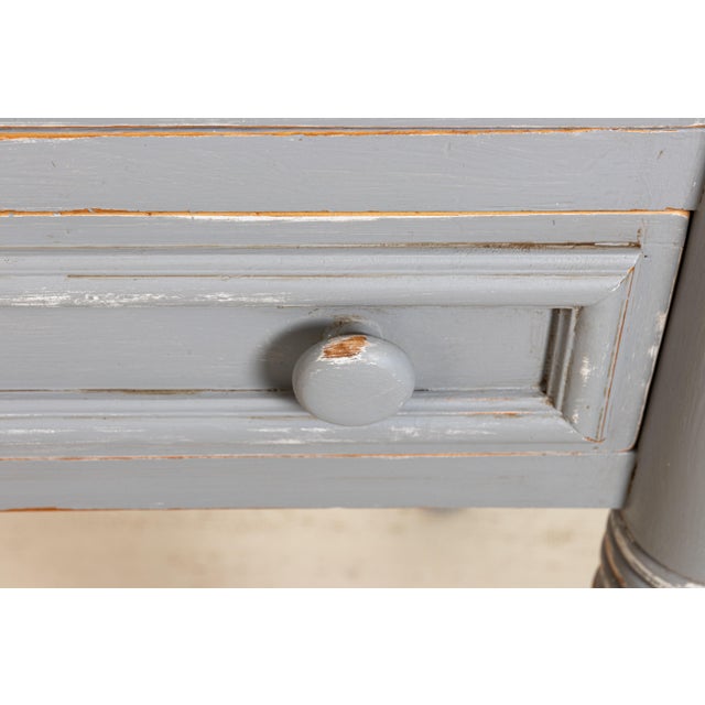 Grey painted two-drawer pine table with cookie cutter corners in a distressed finish, circa 1970s-1980s. Some wear to the...