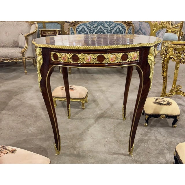 In love with the design. This round table is made with wood and the legs are covered in gold leaf. The details in the...