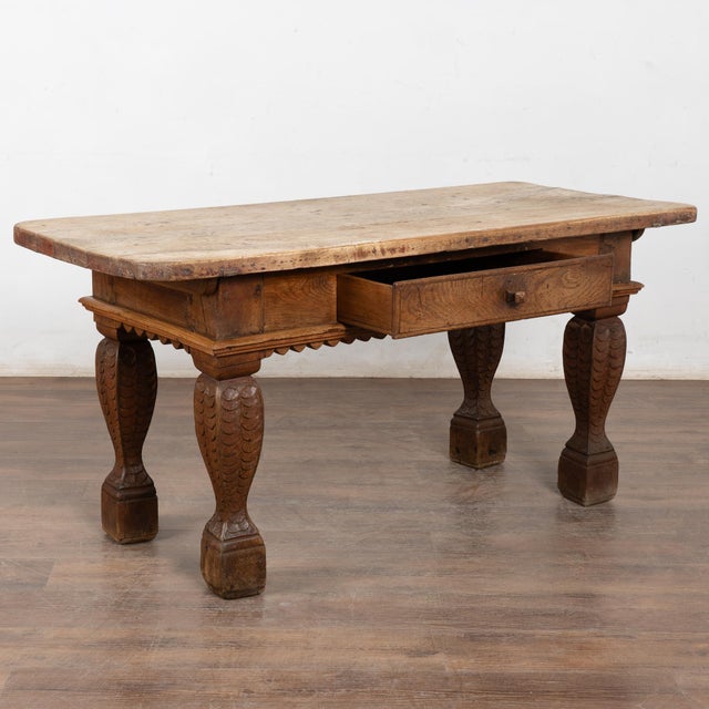This handsome baroque style oak library table with one drawer has heavily turned and carved legs with scalloped skirt. The...