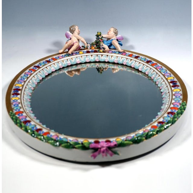 Rare large oval relief porcelain mirror: colourful oval lenses alternate with blue forget-me-not flowers, bordered on the...