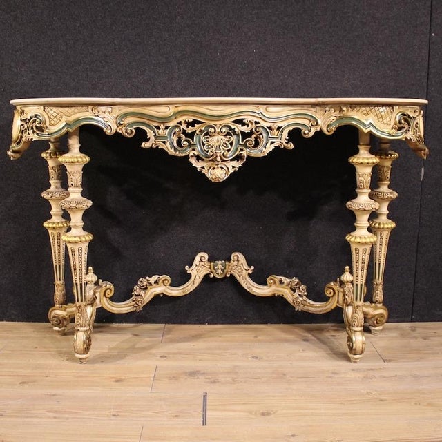 Italian console table from the second half of the 20th century. This eclectic antique-style furniture is richly carved,...