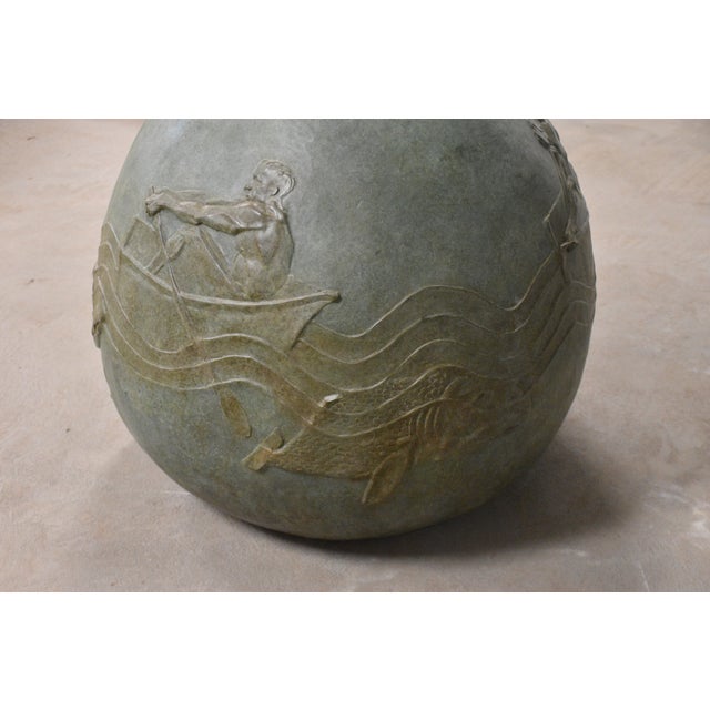 This large bronze planter doubles as a sculptural statement piece, featuring a continuous bas-relief of a rower gliding...