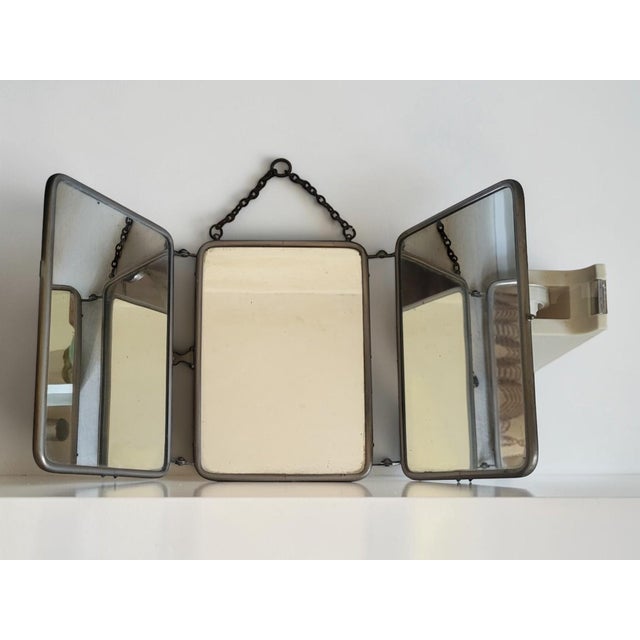 Typical three-panel barber's mirror. In good condition, with minimal signs of wear and age. A few black spots on the...