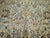 An early 20th century Persian Tabriz rug with light blue and brown dominant accents on an off white field, green border....