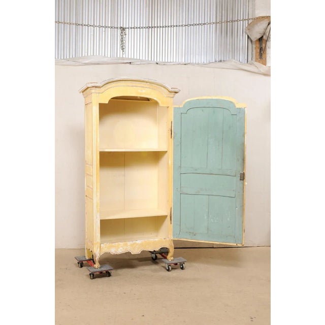 A tall French single-door cabinet, with its original paint, from the 19th century. This antique cupboard cabinet from...
