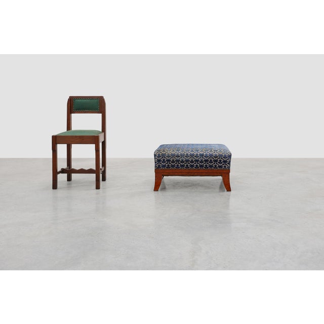 A charming Art Deco ottoman featuring a wooden frame raised on elegant splayed sabre legs. The generously padded seat is...