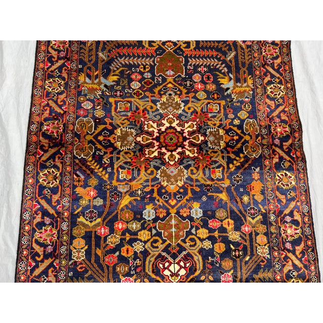 This exquisite vintage Afghan Baluchi rug features a stunning floral medallion pattern on a deep navy background,...