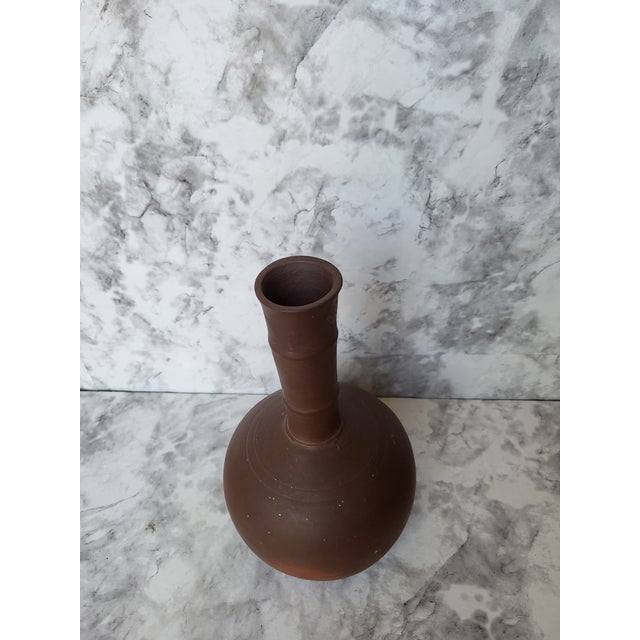 A unique vintage vase made of hand thrown unglazed earthenware. Likely produced in the 1970s. Copper brown or bronze tone...