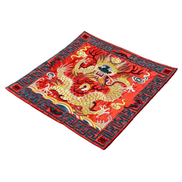 This exquisite square textile features a dynamic embroidered five-clawed imperial dragon commanding a vibrant red field....